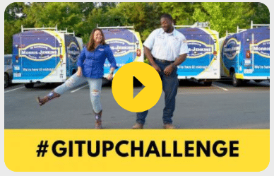 A man and woman standing in front of a truck with the words gitup challenge.