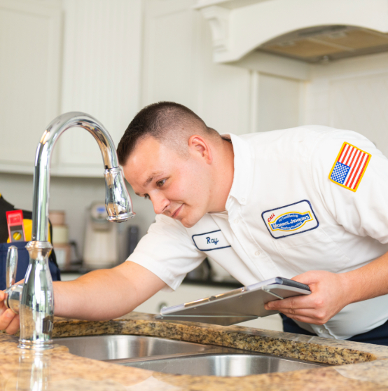 A person in a uniform begins a water quality test.
