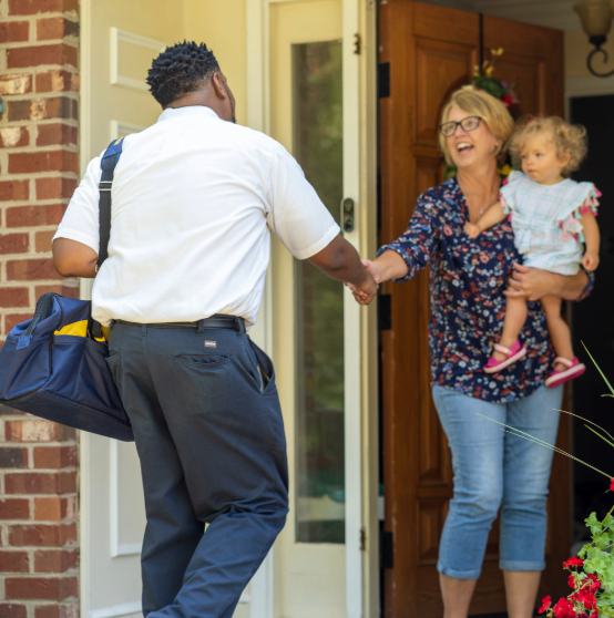 hvac technician greeting a woman and child in need of emergency ac repair